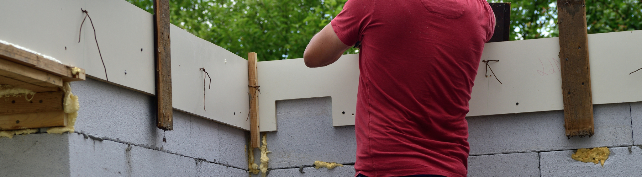 Un maçon coffreur travaillant sur un mur